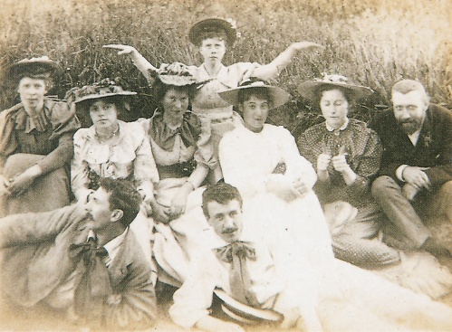 Dörtlü, Clyde Firth&#39;de Dunure&#39;da arkadaşlarıyla tatilde, c.1895. Mackintosh, sağda, solda McNair ile ön planda görülüyor. Margaret Macdonald en solda oturuyor ve resmin en üstünde Frances Macdonald, sağ posterdeki pozu taklit ediyor.